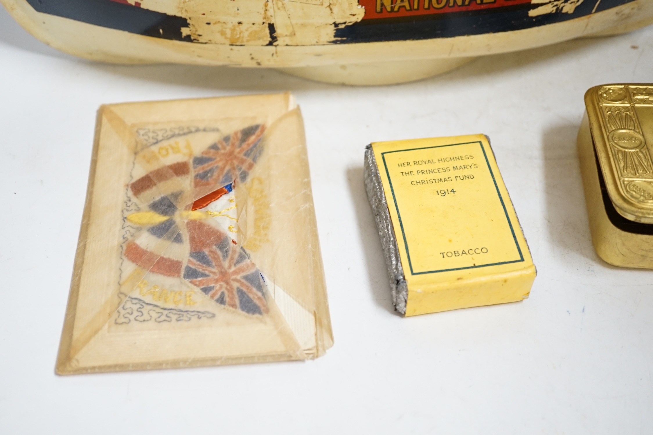 An RNLI sheet metal collecting box in the form of a lifeboat, together with a First World War Princess Mary Christmas tin containing the original tobacco, greetings card, photograph, and other items, plus two early 20th